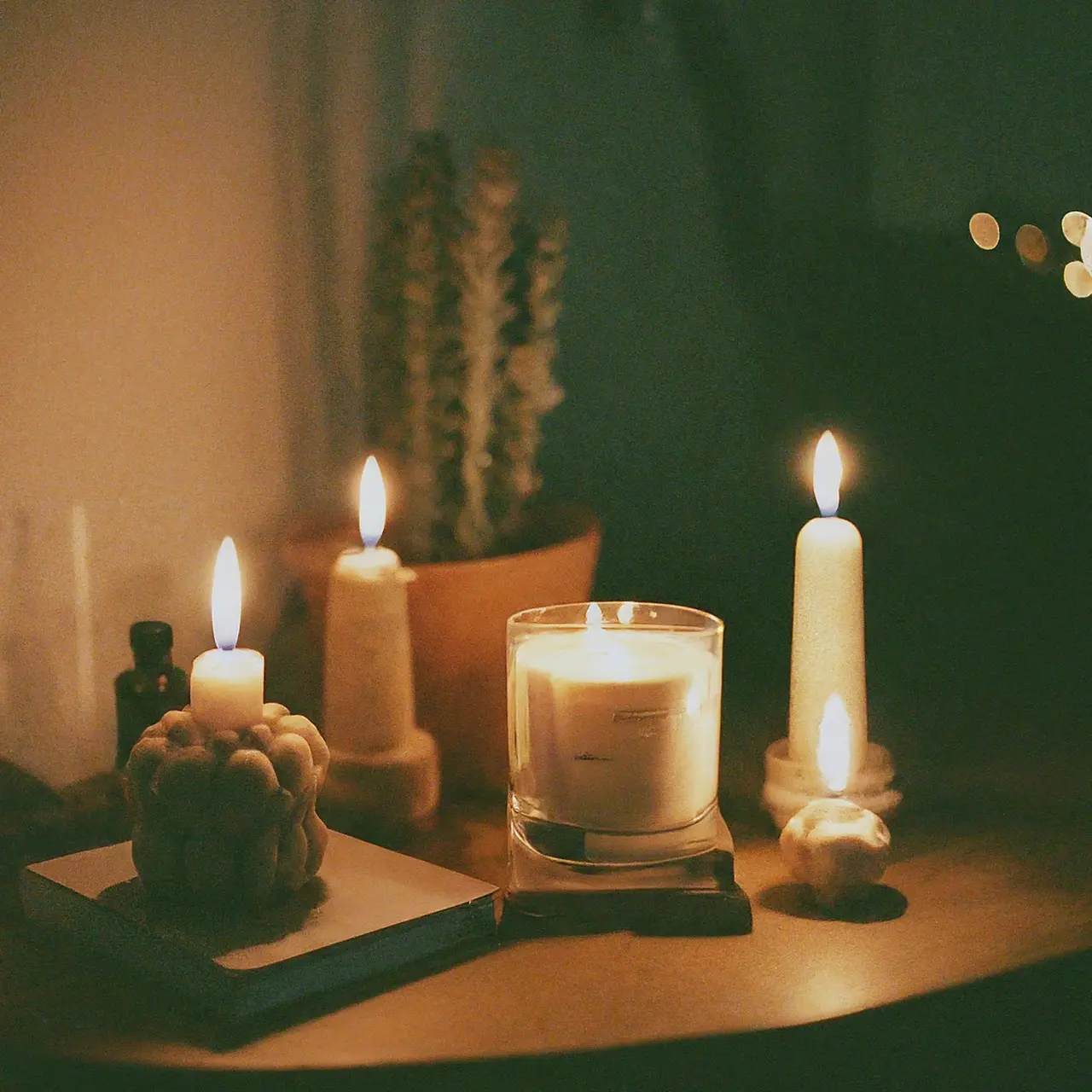 A cozy room lit by several artisan candles. 35mm stock photo