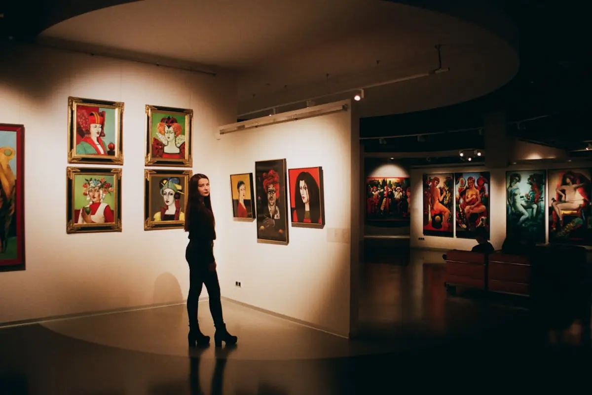 Woman Wearing Black Top Standing Near Paintings