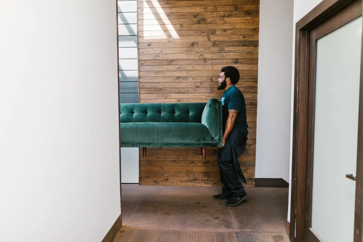 Man in Blue Denim Jeans Sitting on Green Sofa