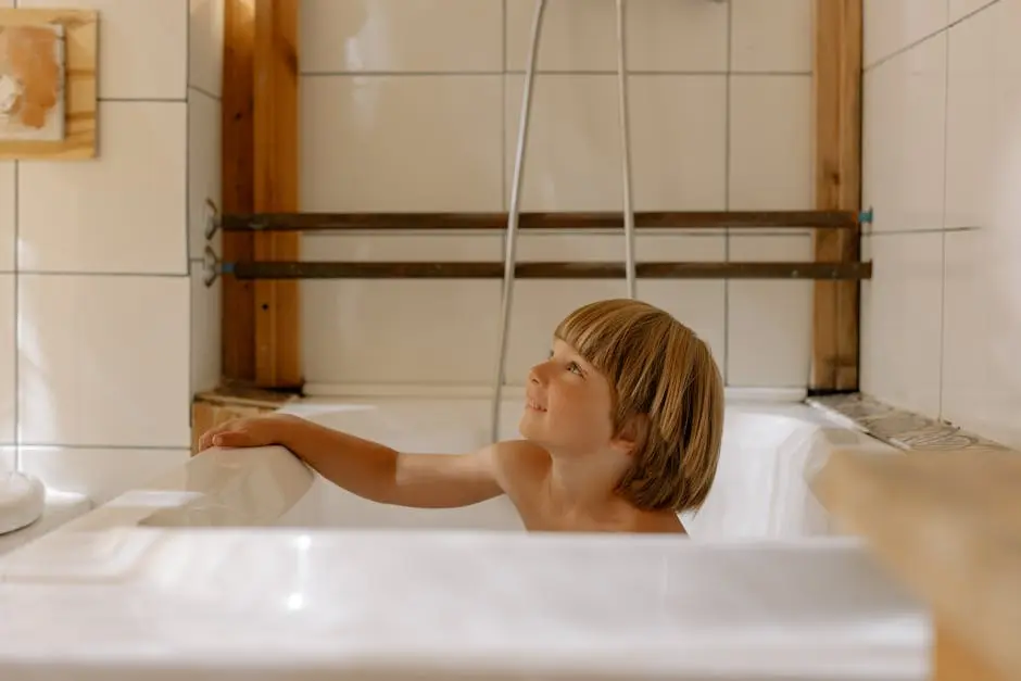 A young boy smiles in a modern, cozy bathroom characterized by warm wooden elements.