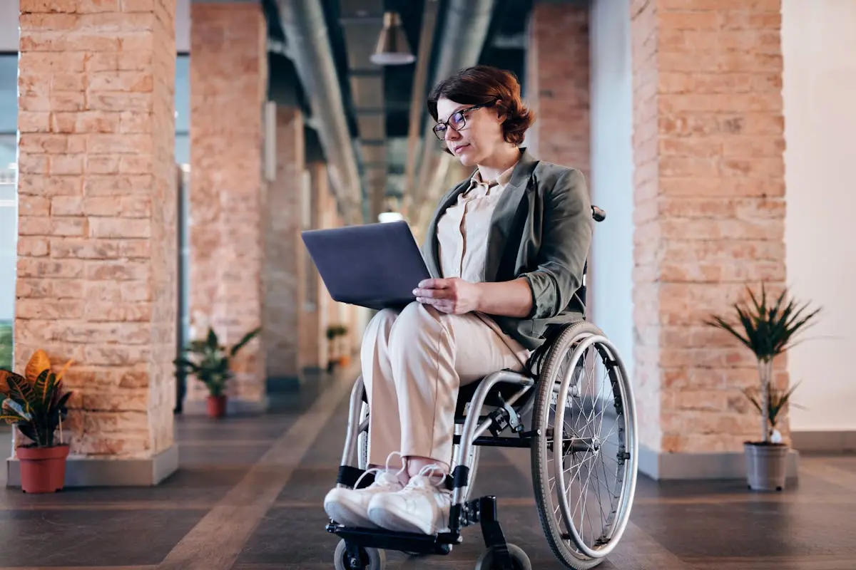 Woman Sitting on Wheelchair While Using Laptop