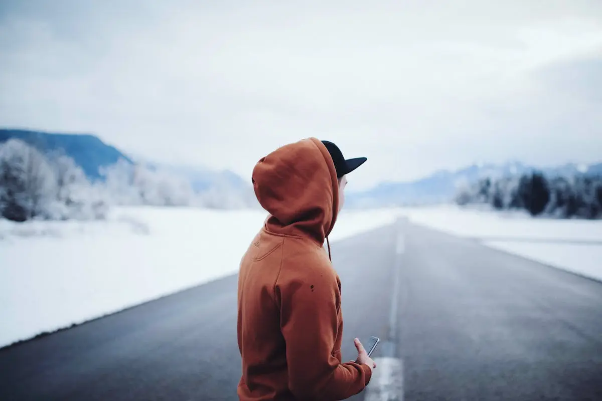 Man Wearing Brown Hoodie in Road