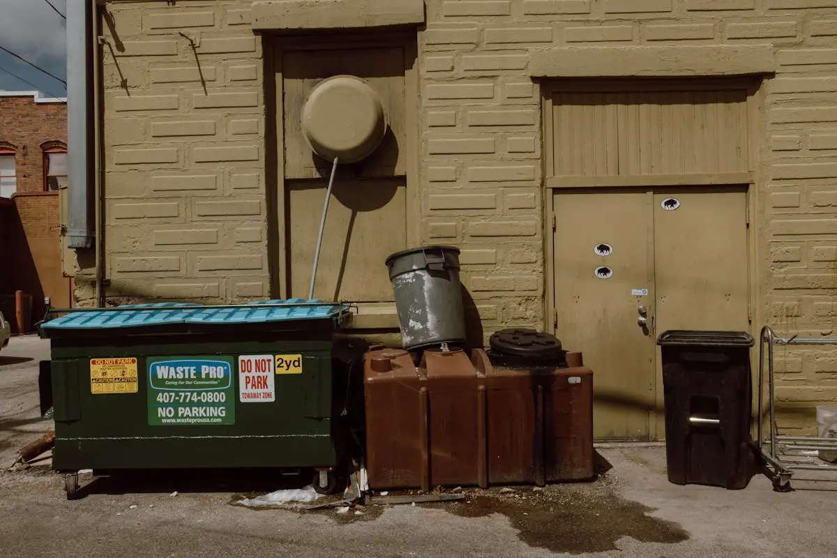 Trash Bins by Sunlit Building Wall