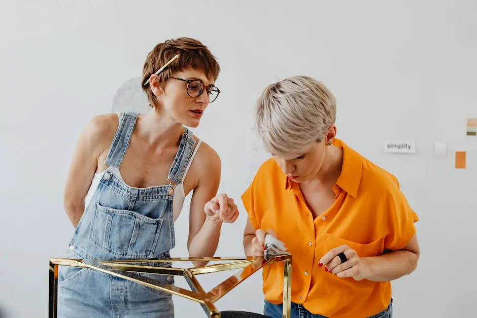 Two women working together on a furniture project, demonstrating teamwork and craftsmanship.