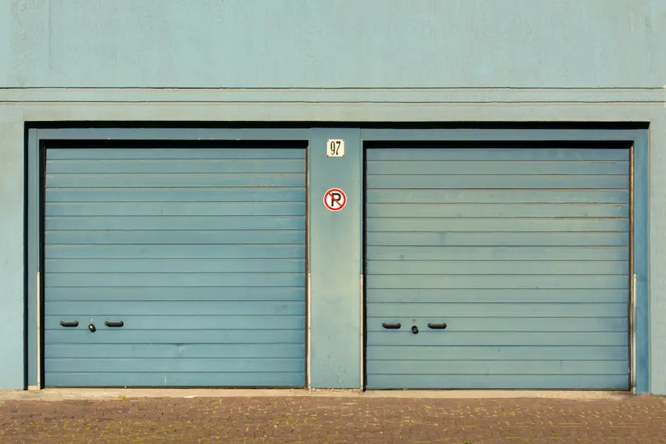 Blue garage doors with a no parking sign painted outdoors.