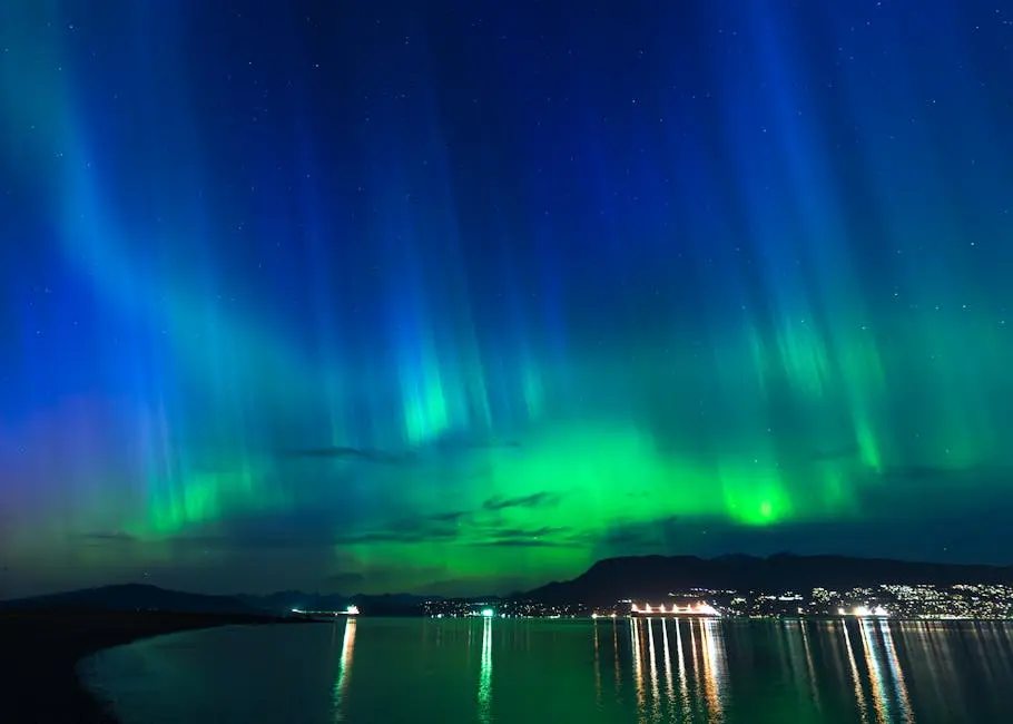 Vibrant aurora borealis illuminating the night sky above a city by the sea.