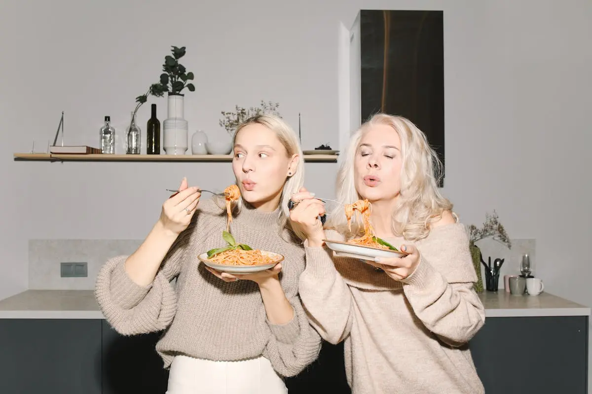 Mother And Daughter Eating Spaghetti