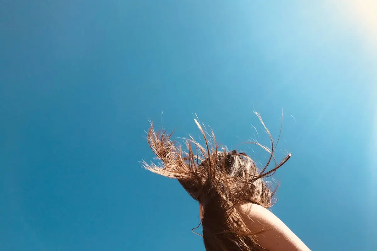 Woman Standing Under Blue Sky