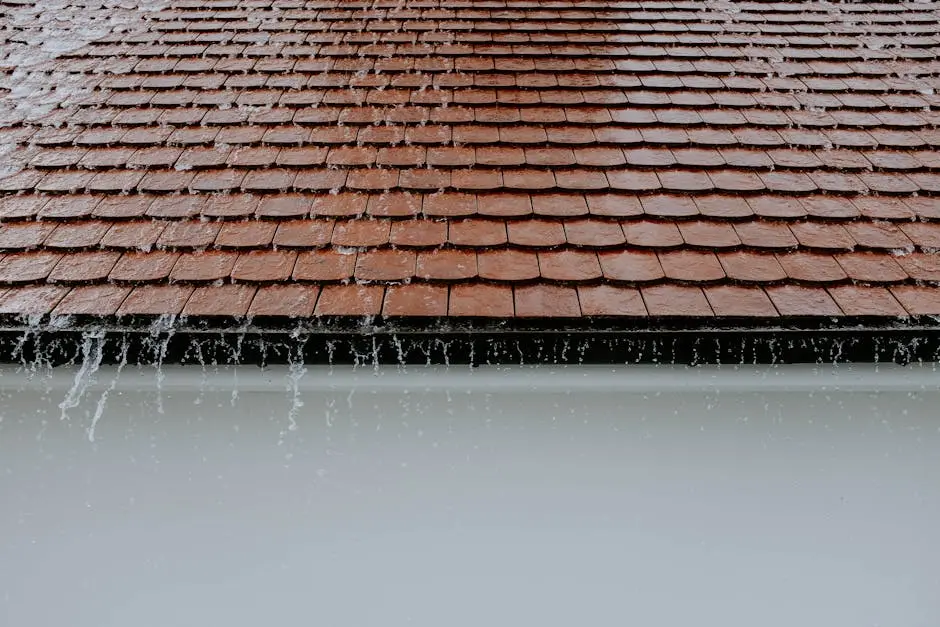 Brown roof tiles with rainwater cascading down, showcasing architectural texture and detail.