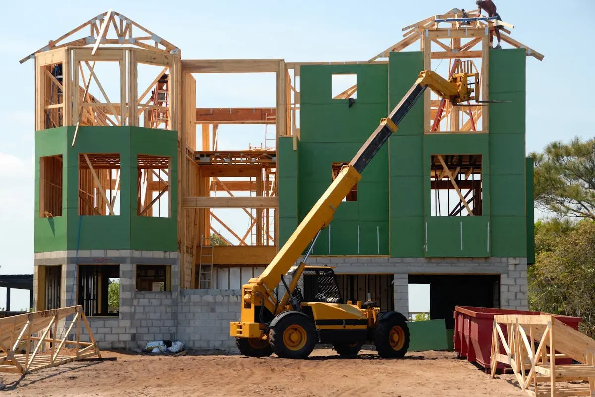 Yellow and Black Heavy Equipment Near Unfinished Building