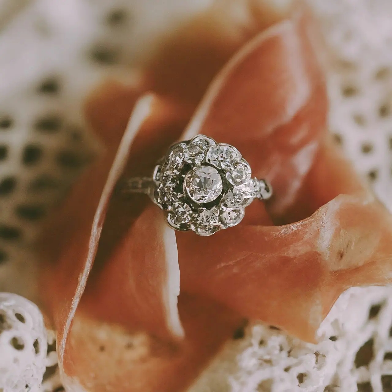 A close-up of a vintage engagement ring on a lace cloth. 35mm stock photo