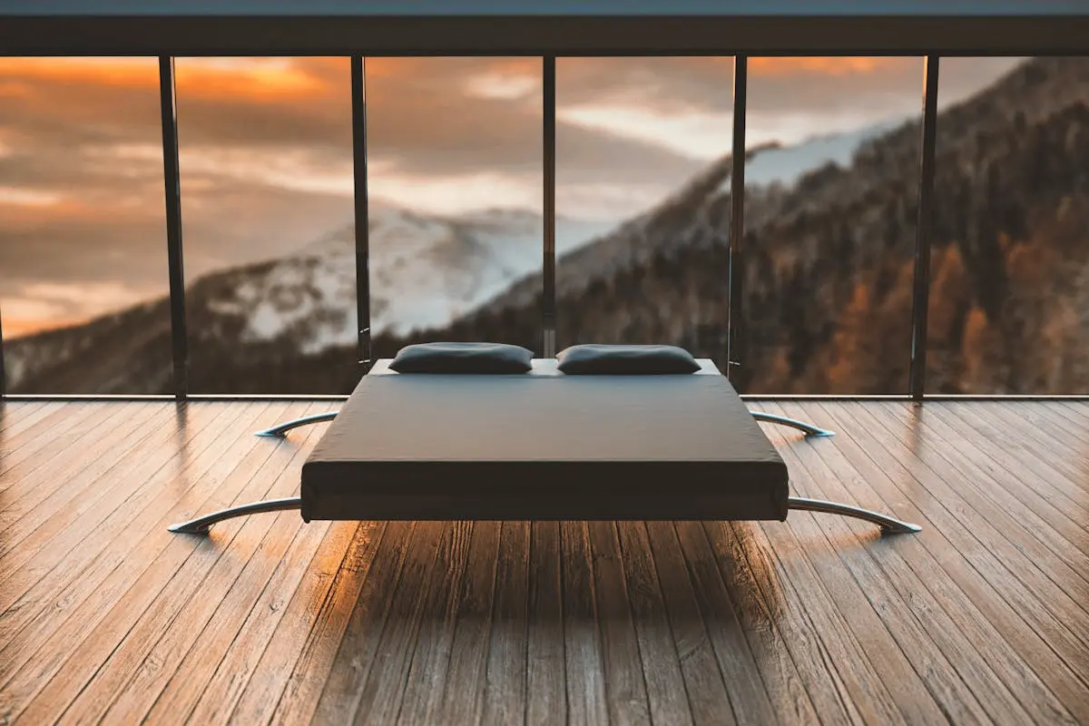 Black Mattress in Front of a Large Window Behind a Mountain