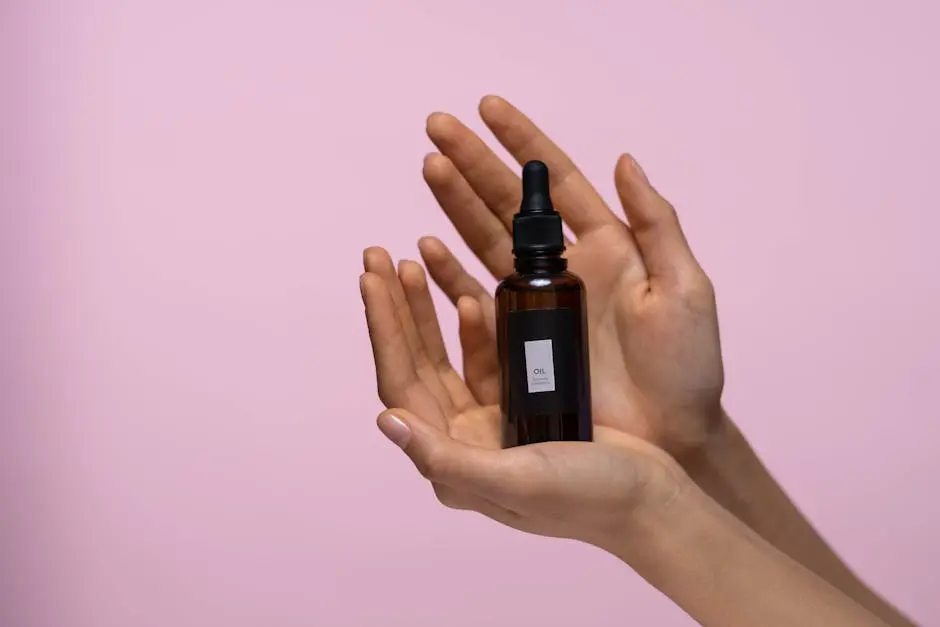 Person Holding A Brown Glass Bottle Of Serum