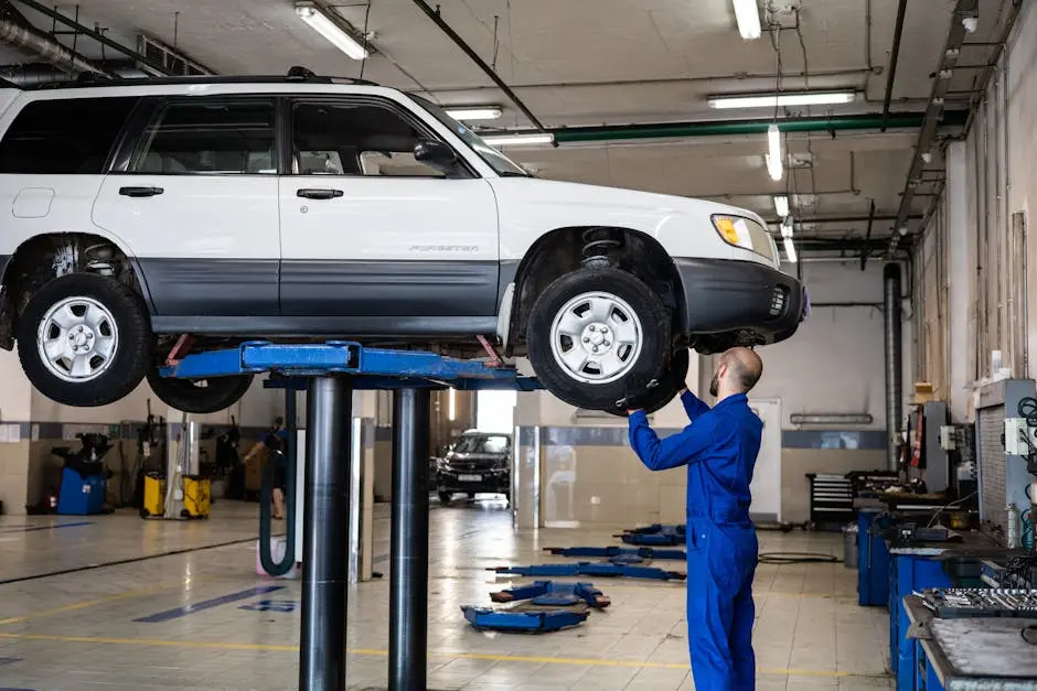 A mechanic inspecting a white SUV lifted in a well-lit auto repair shop.