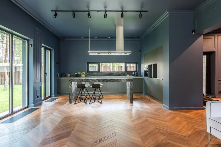 Spacious modern kitchen featuring chevron parquet flooring and sleek design.