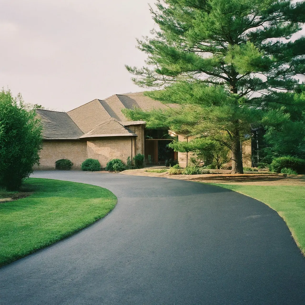 A smooth asphalt driveway leading to a modern home. 35mm stock photo