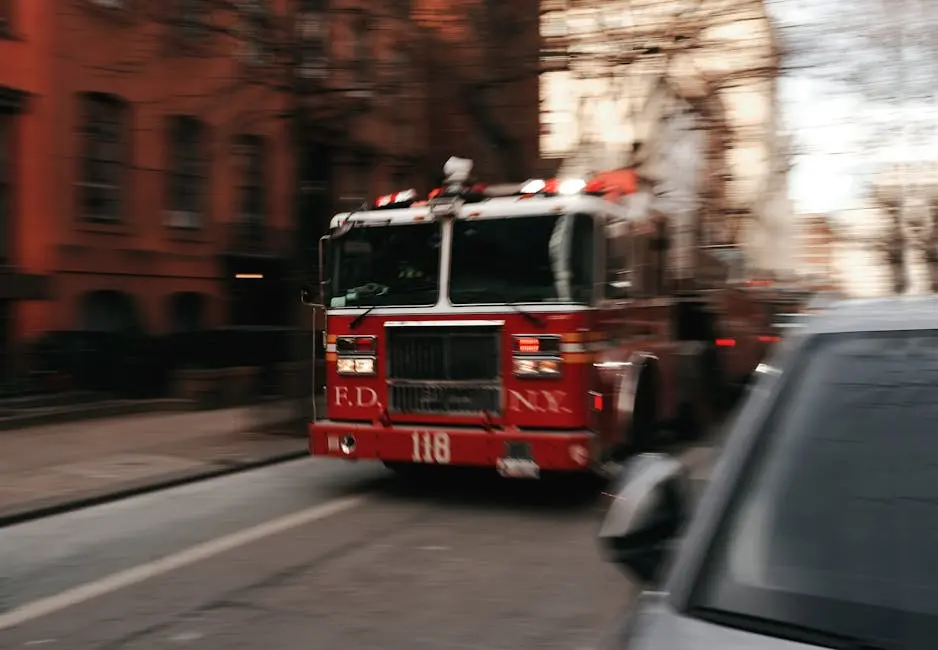 Fire truck speeding through New York City street, capturing the urgency of emergency response.