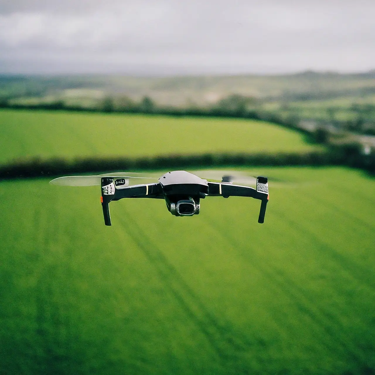 A DJI T40 drone flying over lush green farmland. 35mm stock photo