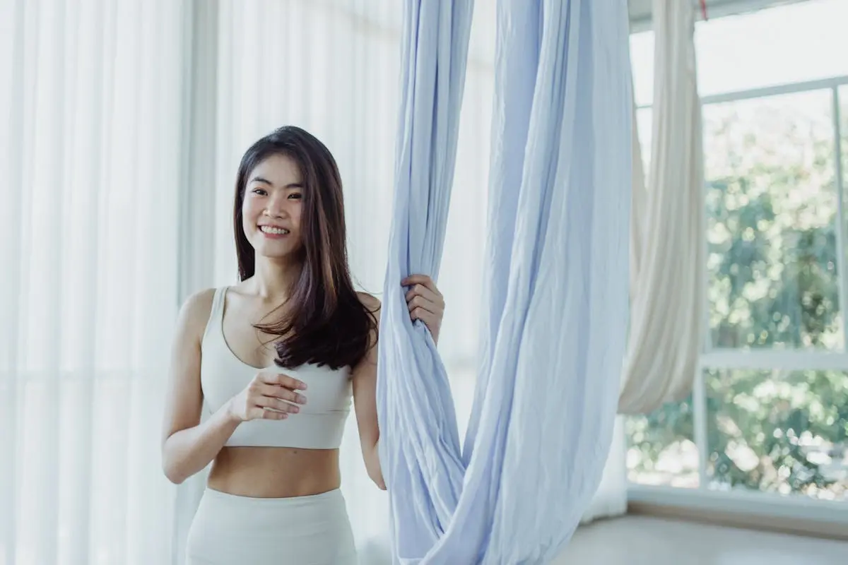 Sexy Woman in White Sports Bra Holding an Aerial Silk