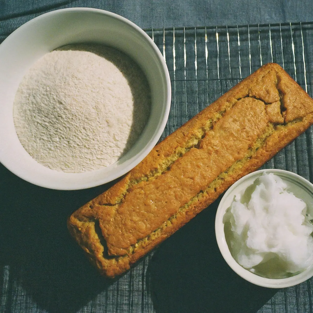 Loaf of keto bread beside almond flour and coconut oil. 35mm stock photo