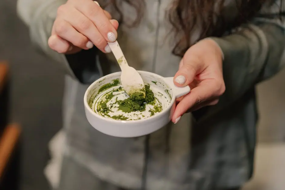 Person Holding White Ceramic Cup With Green Powder