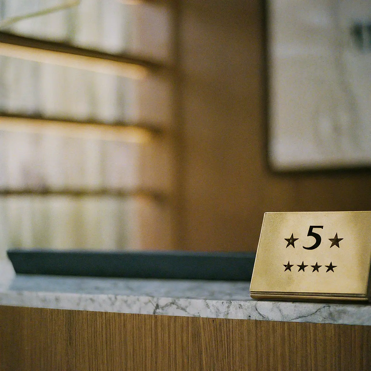 A hotel front desk with a five-star review plaque. 35mm stock photo