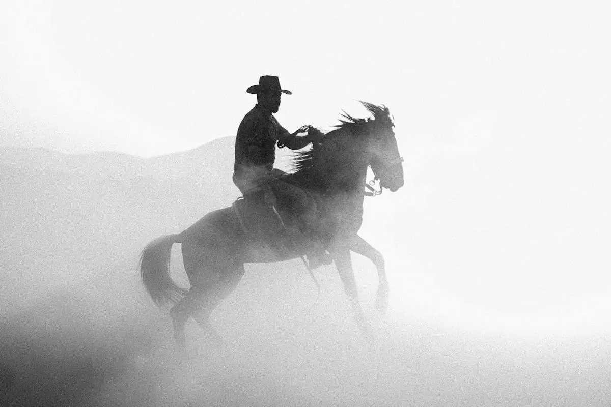 Cowboy Riding a Horse Through a Dust Cloud