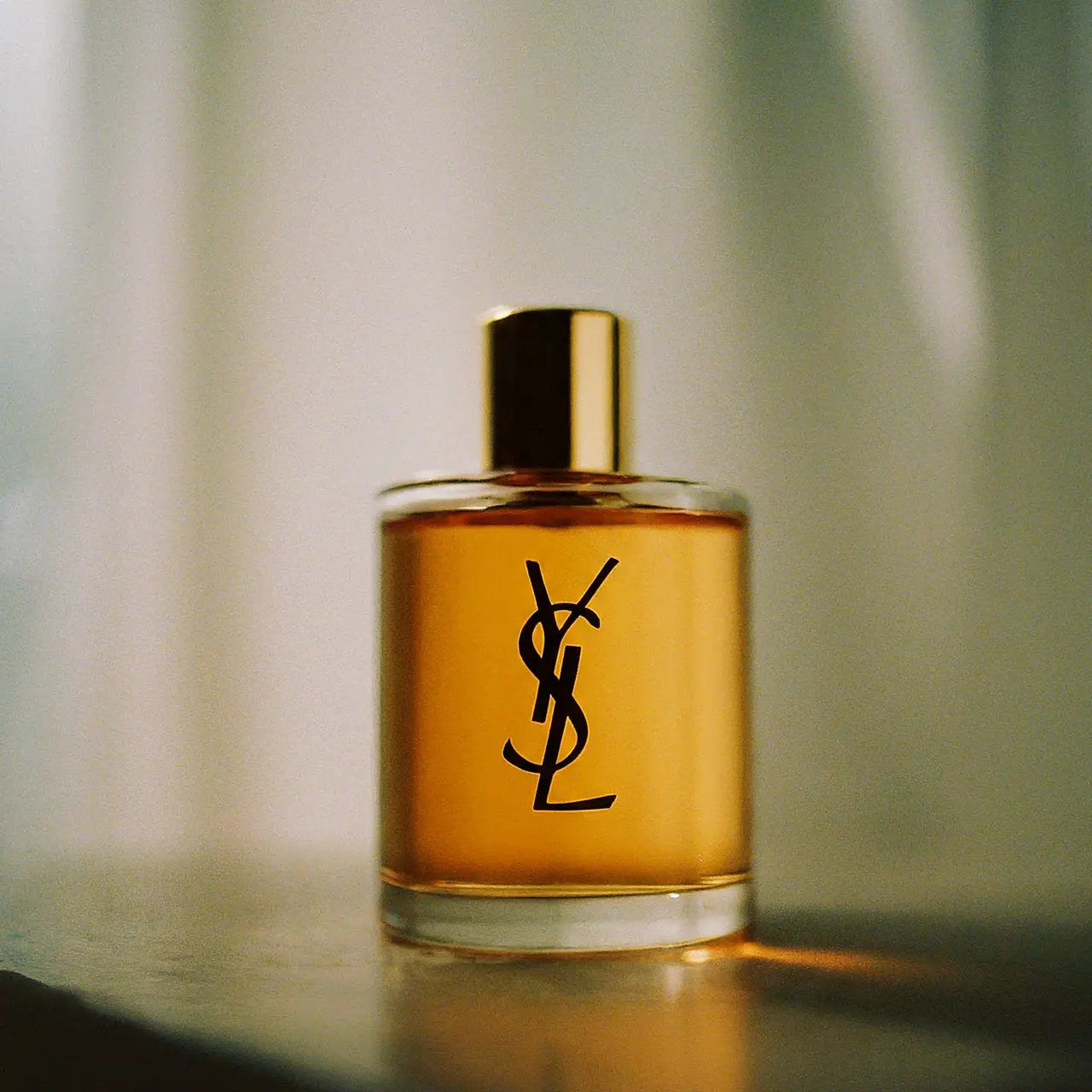 A YSL fragrance oil bottle with a light, elegant background. 35mm stock photo