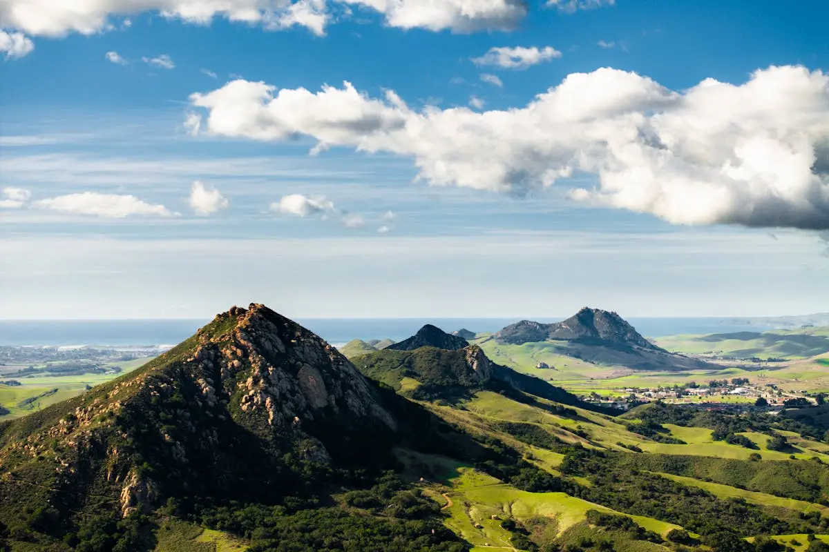 A breathtaking aerial view of the lush green hills in San Luis Obispo, California, under a vibrant sky.