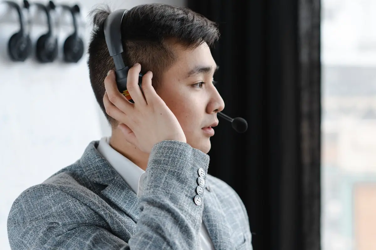 Man in Gray Sweater Using Black Headphones