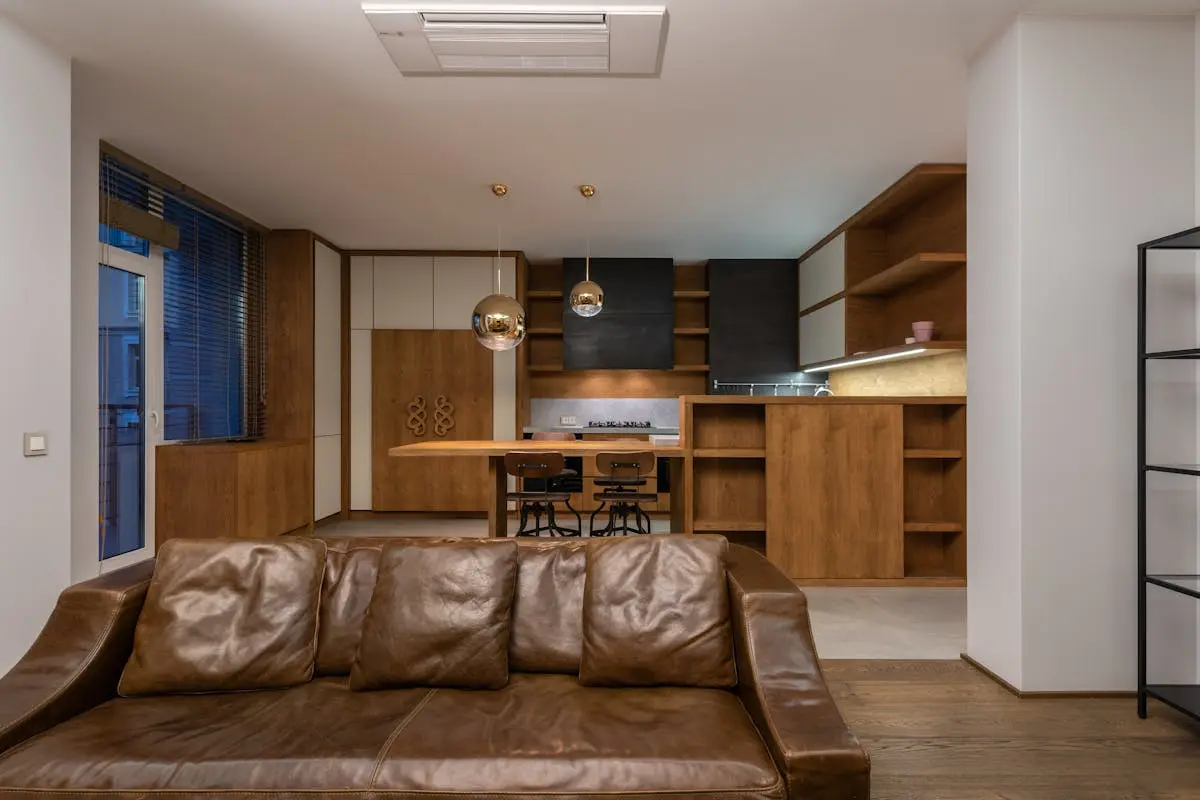 Luxury brown sofa near wooden furniture of modern apartment