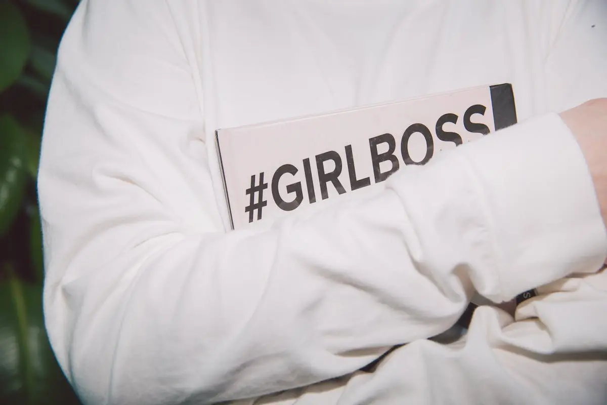 Close-up of a woman holding a #GirlBoss book, symbolizing empowerment and feminism.