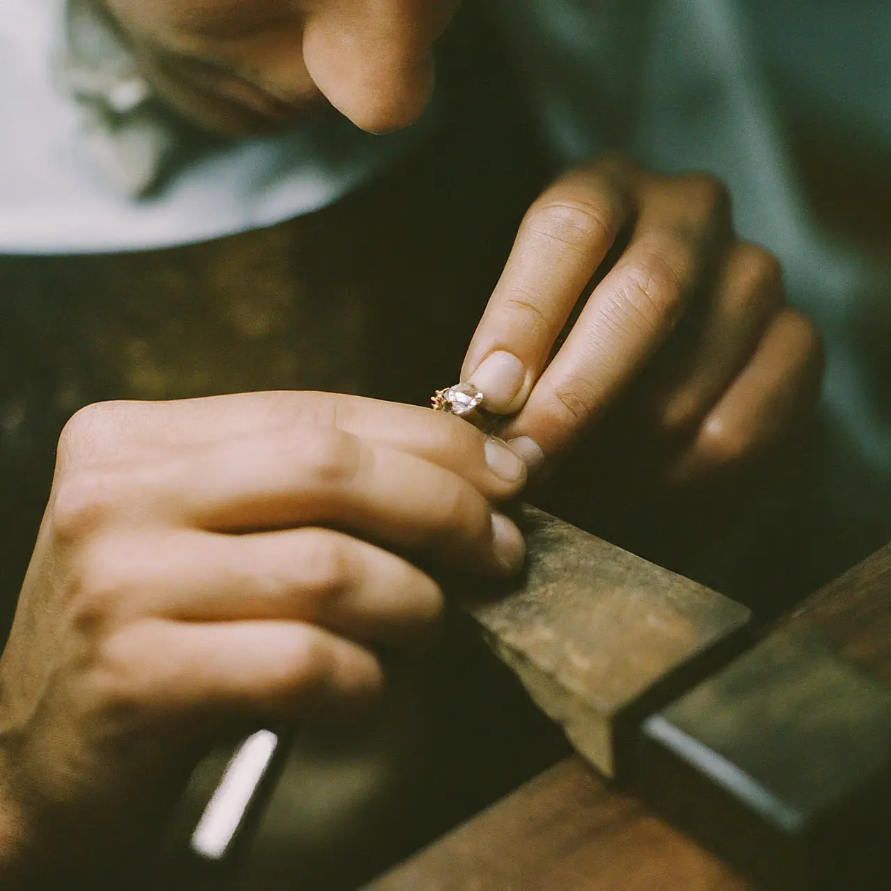 Close-up of jeweler’s hands crafting a diamond engagement ring. 35mm stock photo