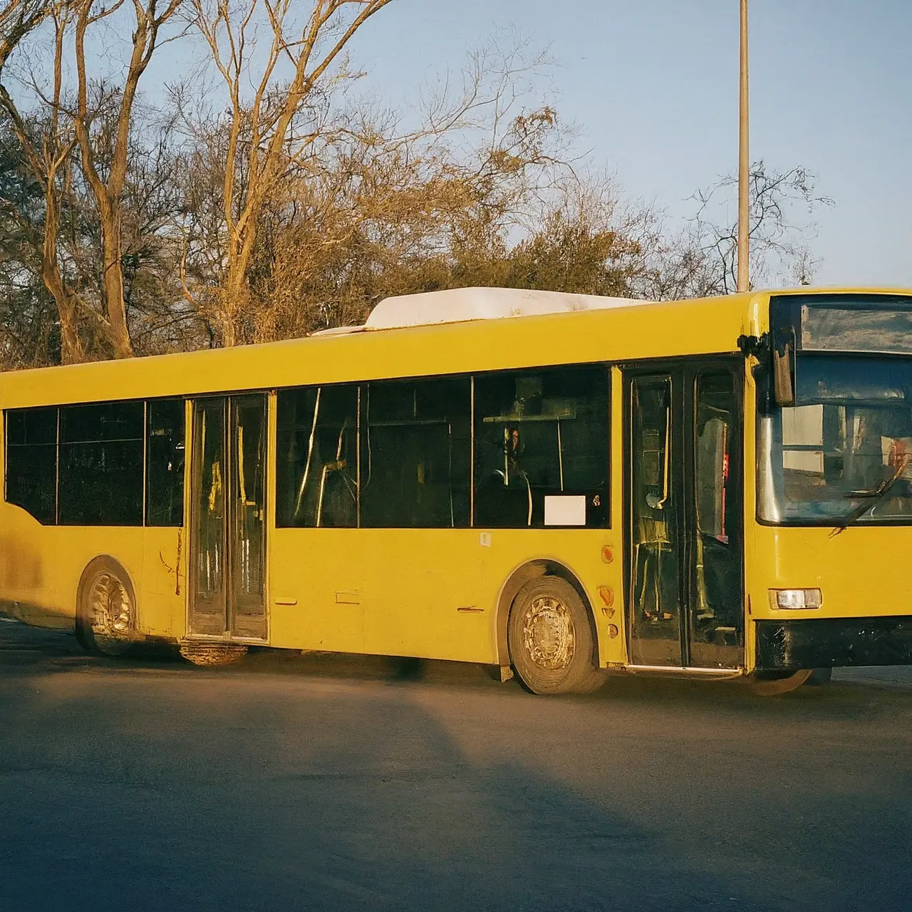 A city bus equipped with a wheelchair ramp at sunset. 35mm stock photo