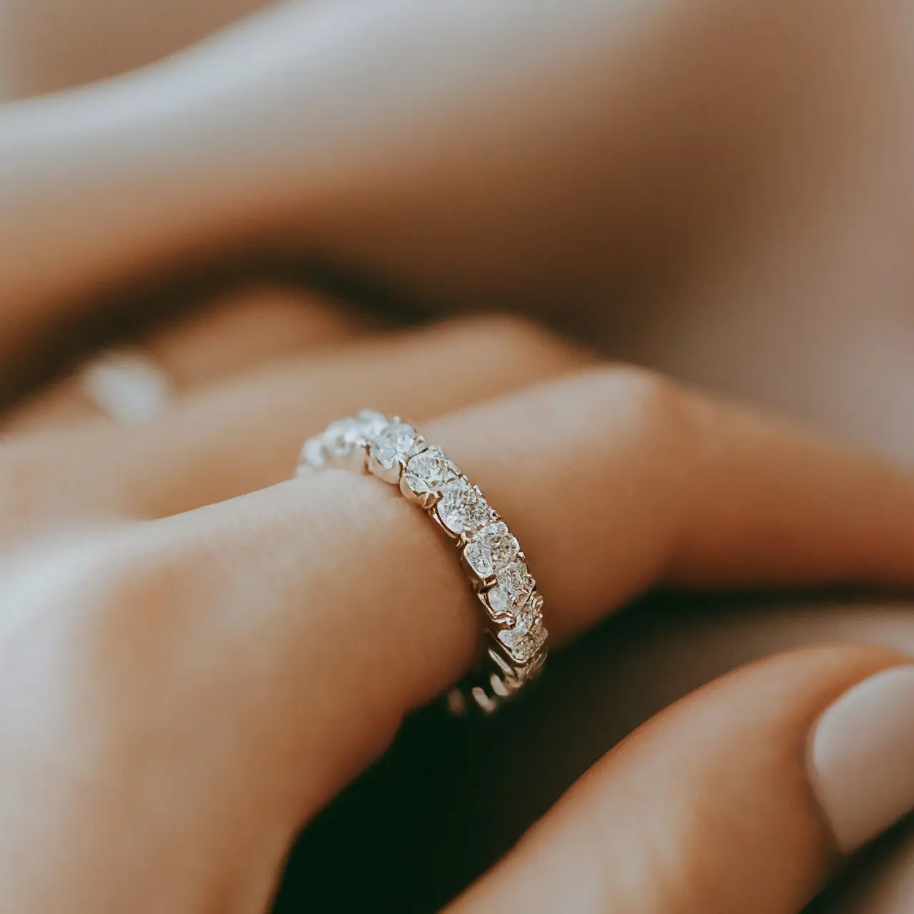 A close-up of a diamond eternity band on silk fabric. 35mm stock photo