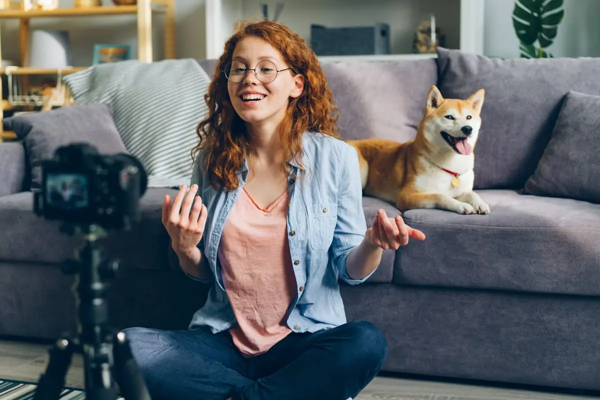 Happy woman with Shiba Inu dog filming a vlog at home. Perfect for content creators and pet lovers.