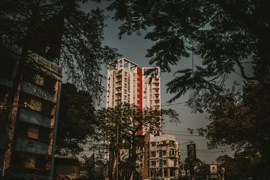 Tall residential building amidst urban street and trees, captured in soft, warm tones.