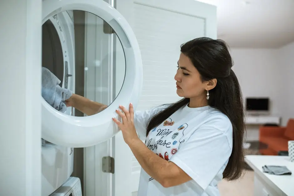 A woman loads clothes into a modern washing machine, focusing on laundry in a stylish home setting.