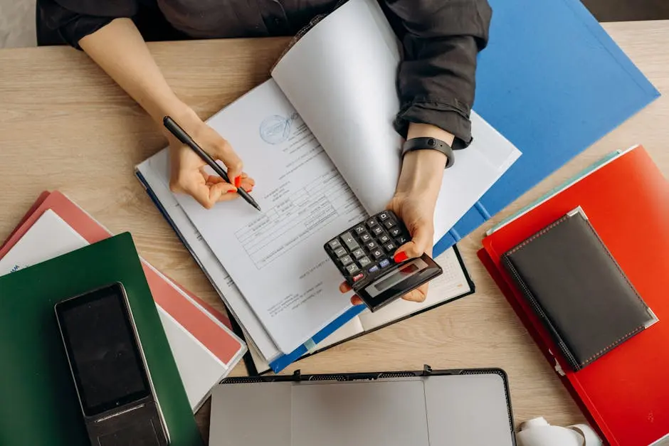 Accountant analyzing financial documents with a calculator on a desk, highlighting business tasks.