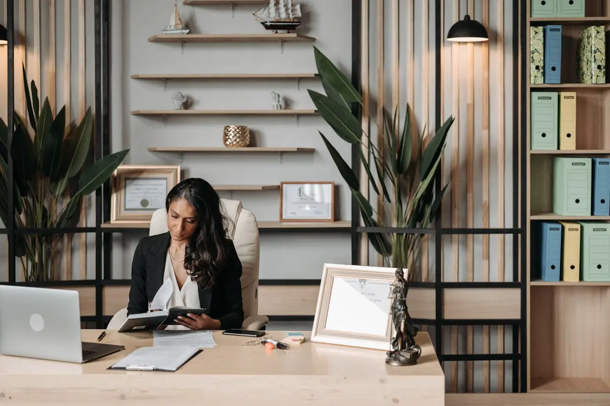 Woman in black blazer inside her private workstation decorated with office plants