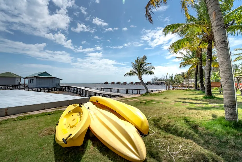 Vibrant seaside scene featuring yellow kayaks on a tropical beach with palm trees.