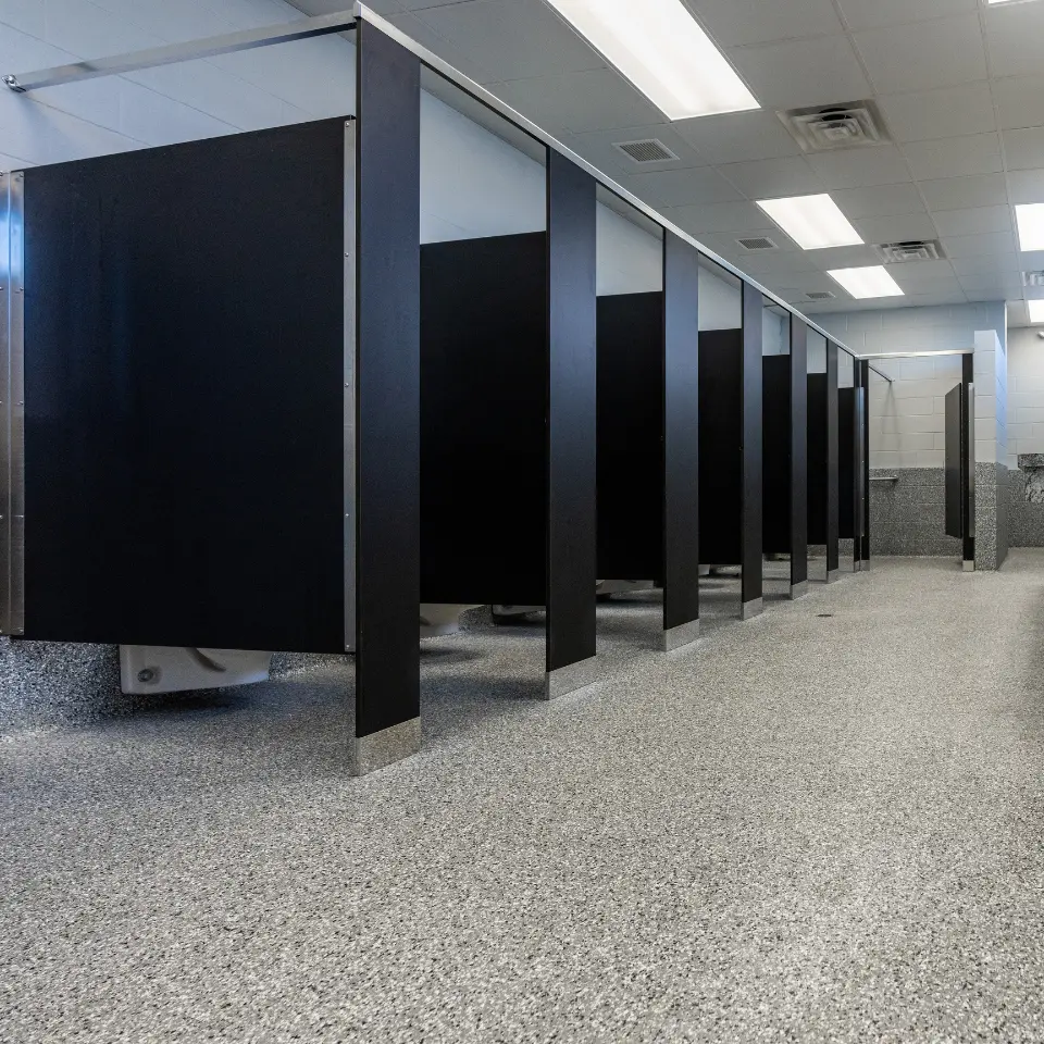 A modern bathroom featuring sleek Elite Coatings Penntek industrial flooring, showcasing its durable, slip-resistant surface with a polished finish, complementing the contemporary fixtures and clean lines. Garage Flooring company.