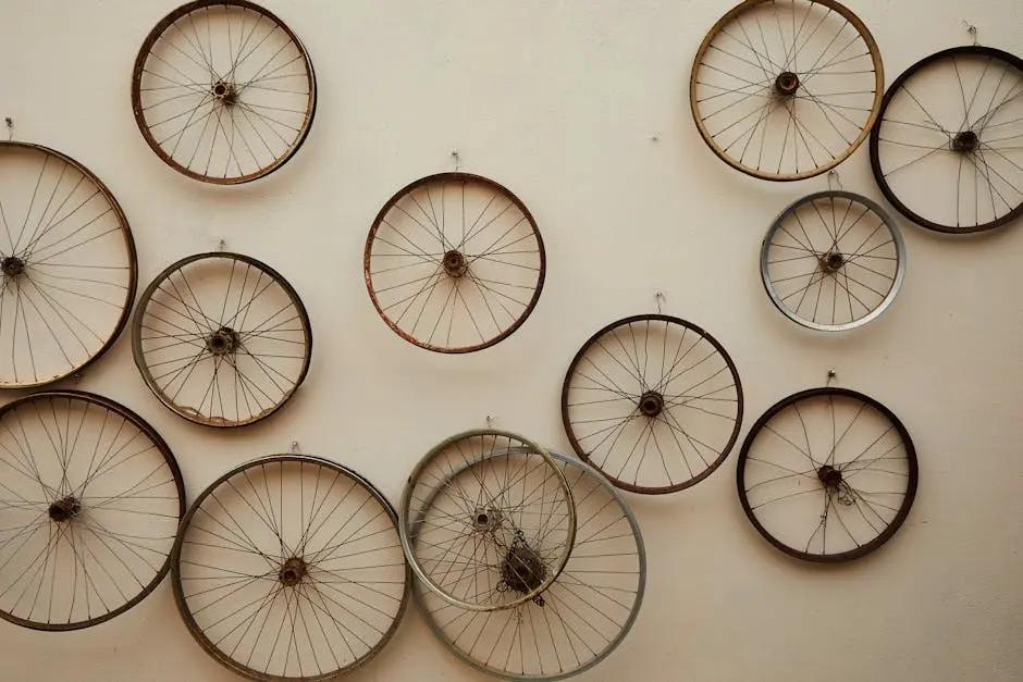 Different shapes and sizes spoke wheels hanging on light wall