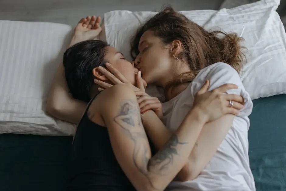 An intimate moment of love and connection between a couple lying on a bed, embracing and kissing.