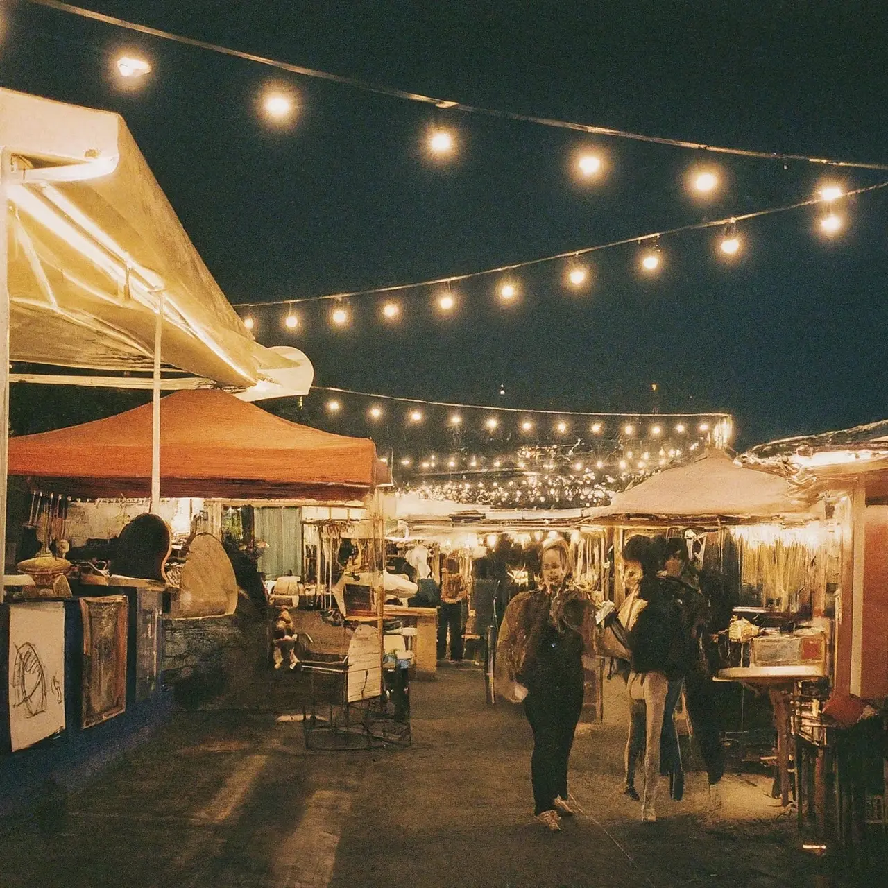 A vibrant street food market under twinkling evening lights. 35mm stock photo