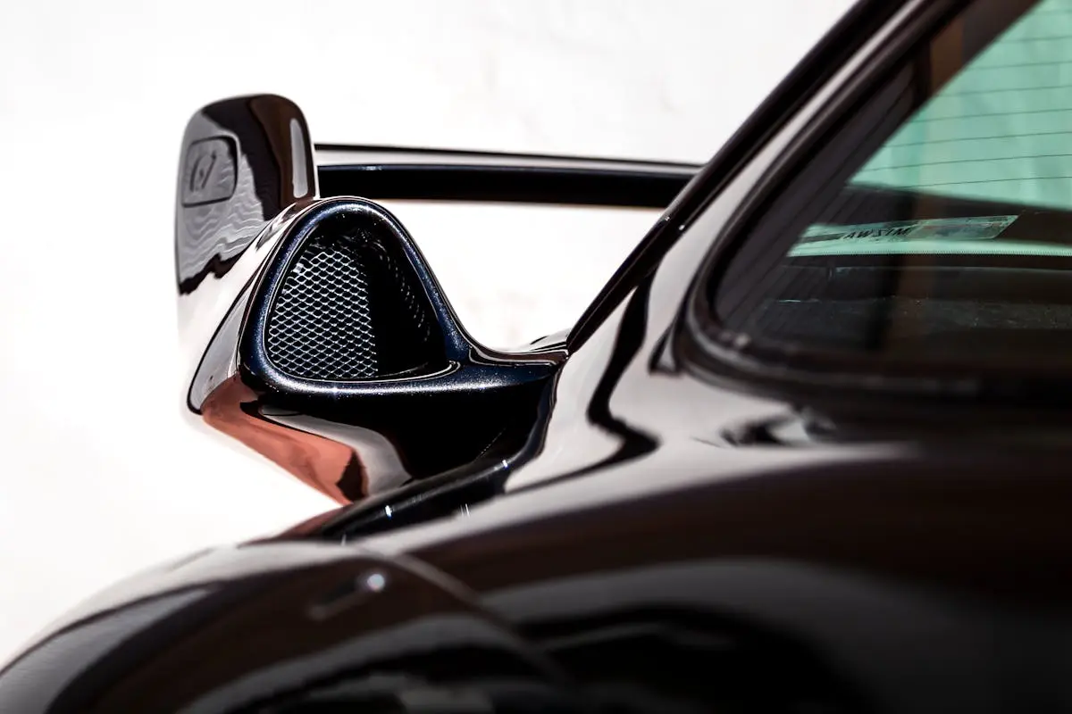 Detailed view of a luxury car’s aerodynamic vent on a sleek black body.