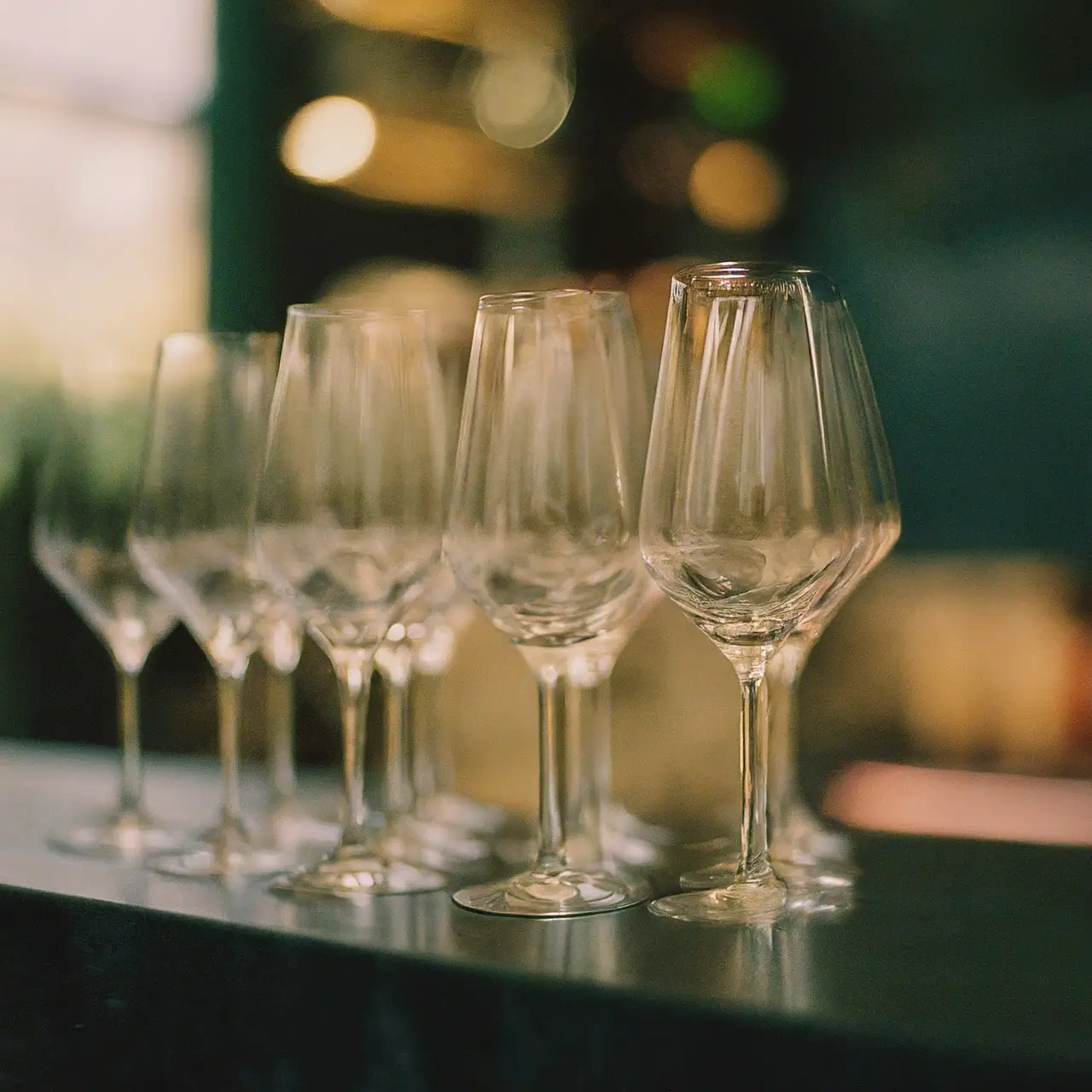 Elegant highball glasses arranged on a sleek bar counter. 35mm stock photo
