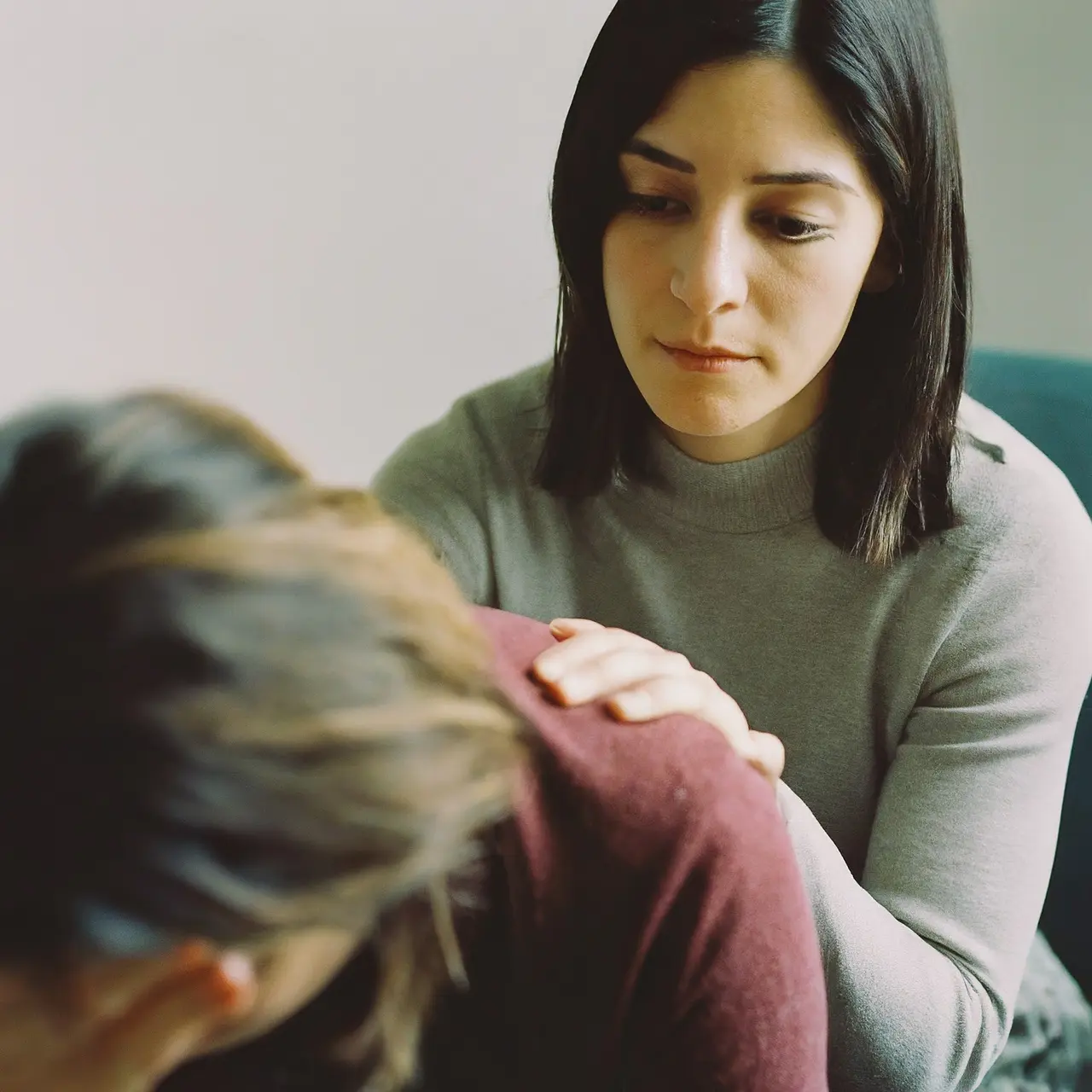 A calm therapist comforting a distressed patient in an office. 35mm stock photo