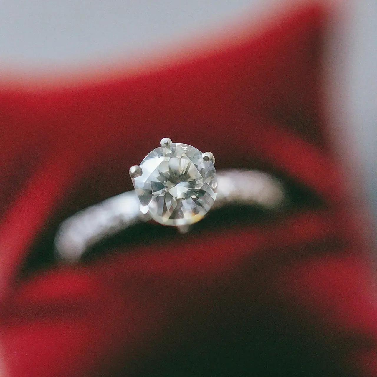 A sparkling diamond engagement ring on a velvet cushion. 35mm stock photo