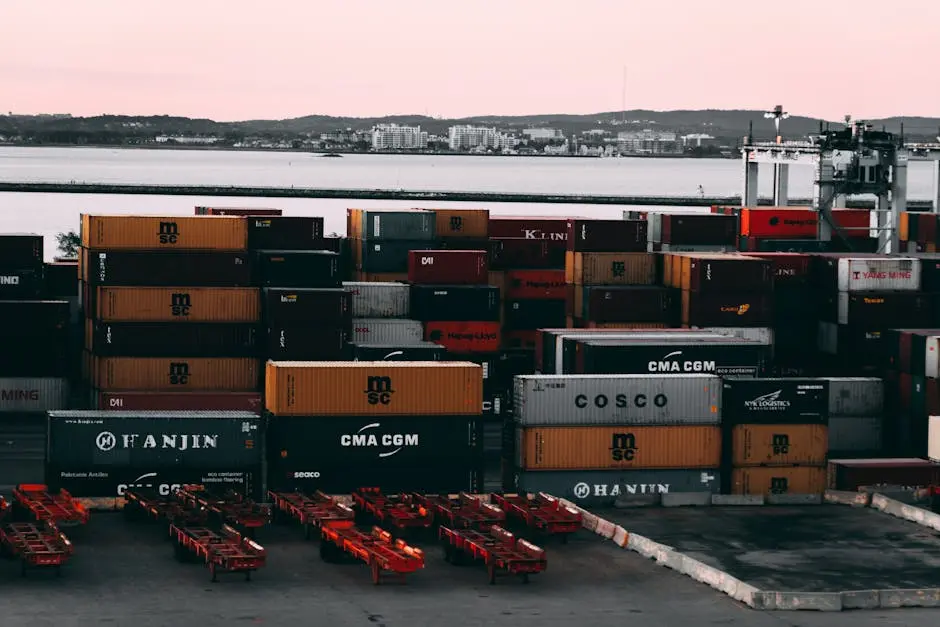 A bustling container yard at a seaport with shipping containers stacked and ready for transport at twilight.